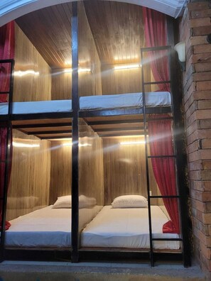 A bunk bed room with wooden walls and a brick wall on one side. - Hangover Hostel Patong (Patong)