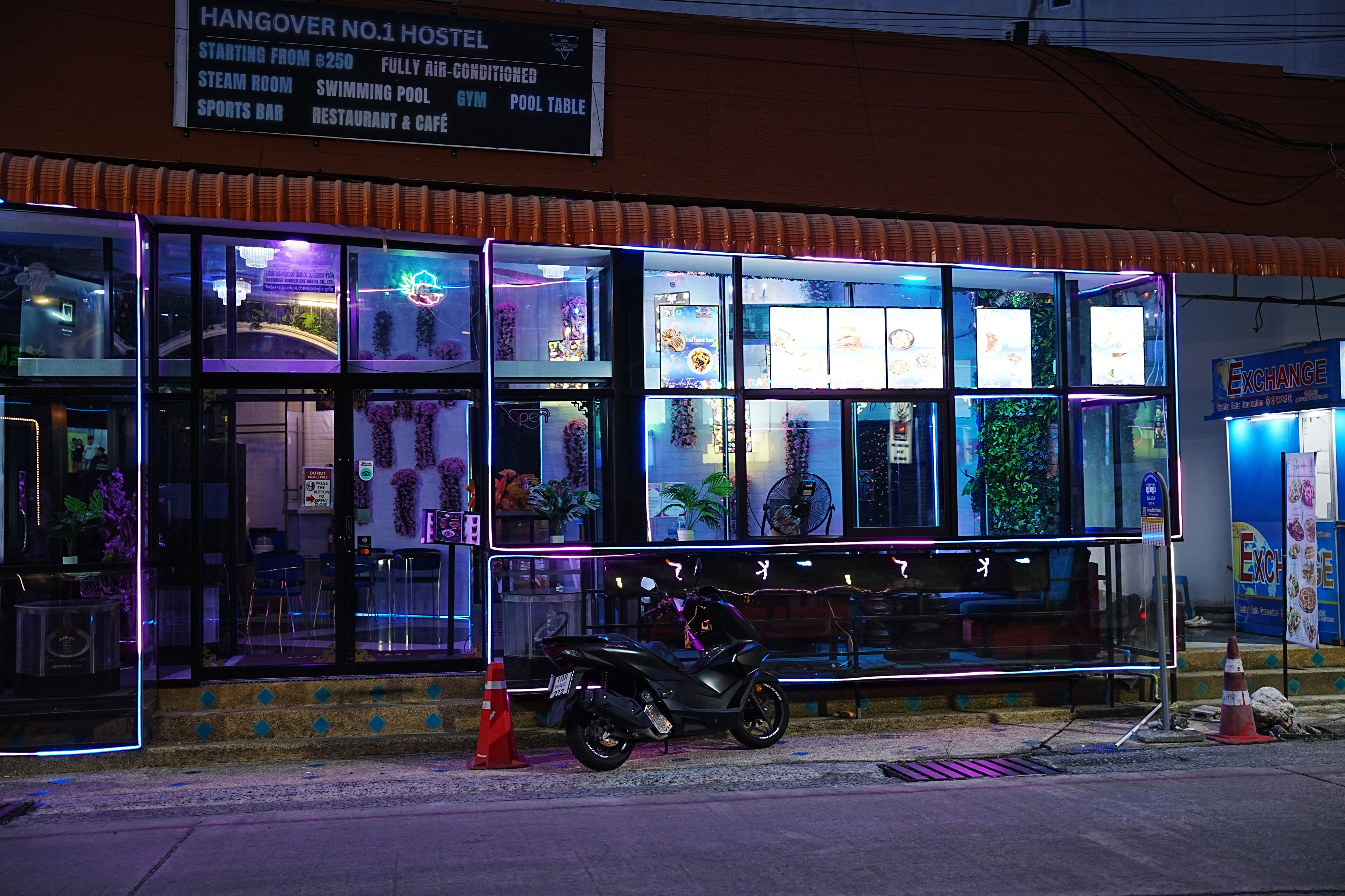 A hostel with a sign indicating amenities such as a swimming pool, gym, and restaurant.