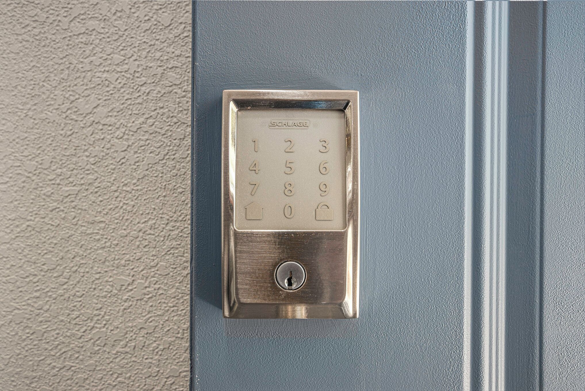 A metallic door lock with a numeric keypad, SCHLAGE brand, and a keyhole below.