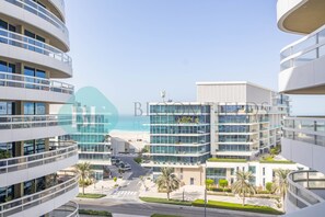 Et moderne hotel med flere etager, store vinduer og udsigt til stranden.