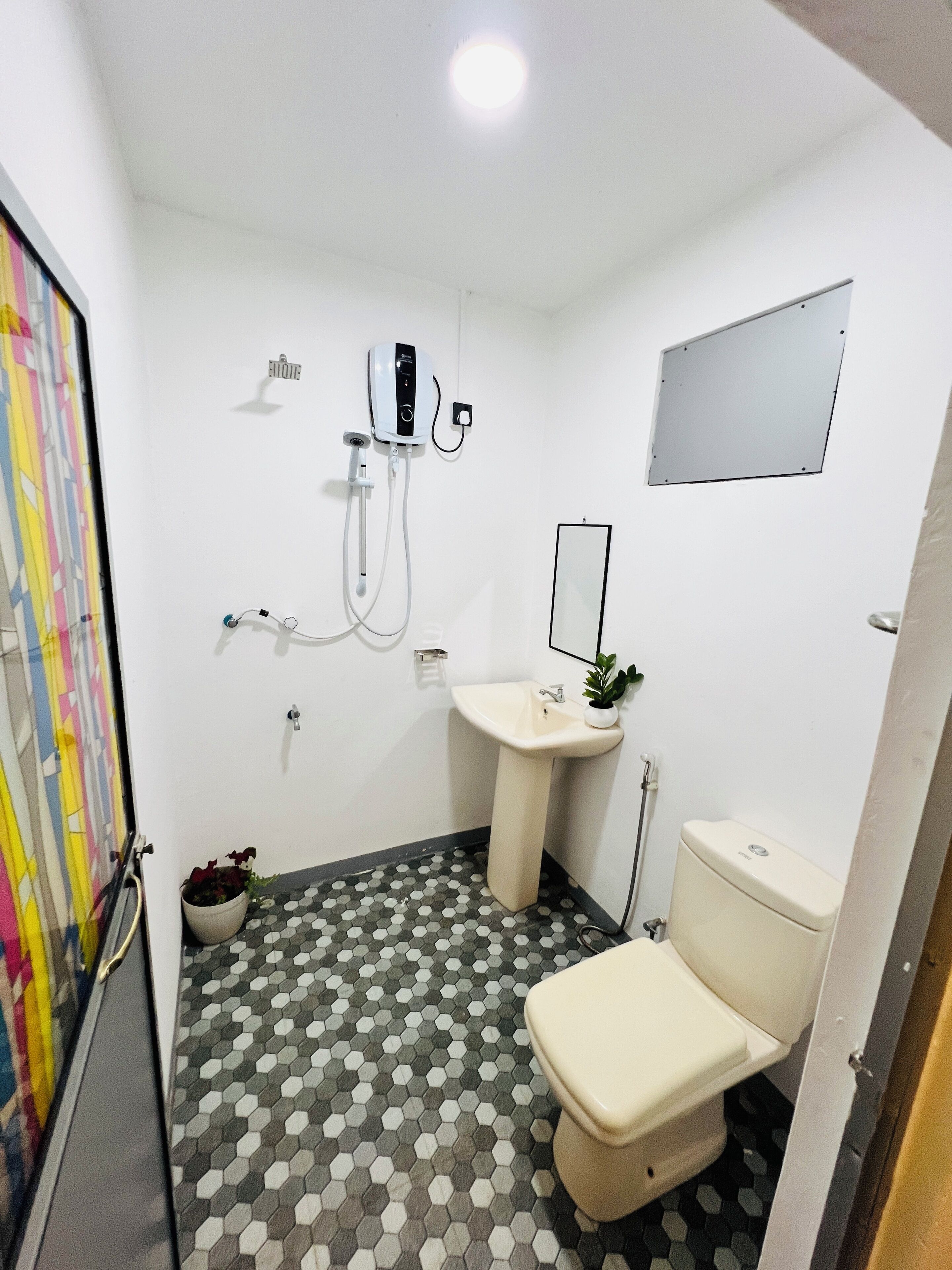 Un baño con inodoro, lavamanos y ducha.
