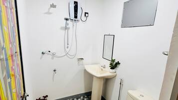 Un baño con inodoro, lavamanos y ducha.
