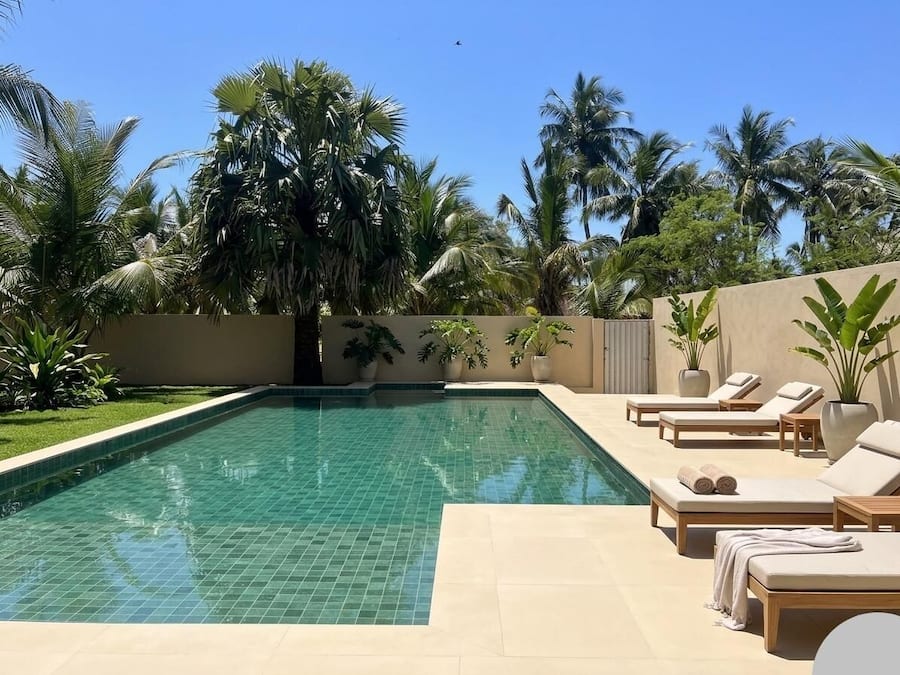 Una piscina al aire libre, sillones reclinables de piscina