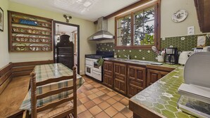 A kitchen with wooden cabinets, a tiled backsplash, and a window overlooking greenery. - House for 10 with large garden, 250m from the sea (Louannec)