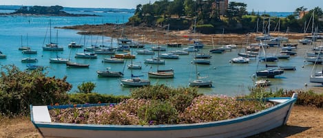 Experience the tranquil marina setting with a picturesque view of the calm waters and a historic landmark in the distance.