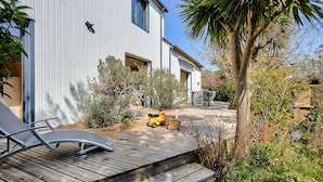 A modern house with a wooden deck, a small garden, and a palm tree. - 600m from the beach, garden, house for 10 (Saint-Briac-sur-Mer)