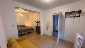 A bedroom with a bed, a bedside table, a mirror, a radiator, and a wardrobe. - Modern city-center gîte in Moulins for 4 with Wifi (Moulins)
