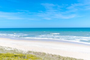 A beach with clear skies and calm waters. - The Sugar Shak - 4 BR Oceanfront Home with Covered Porch (Surf City)