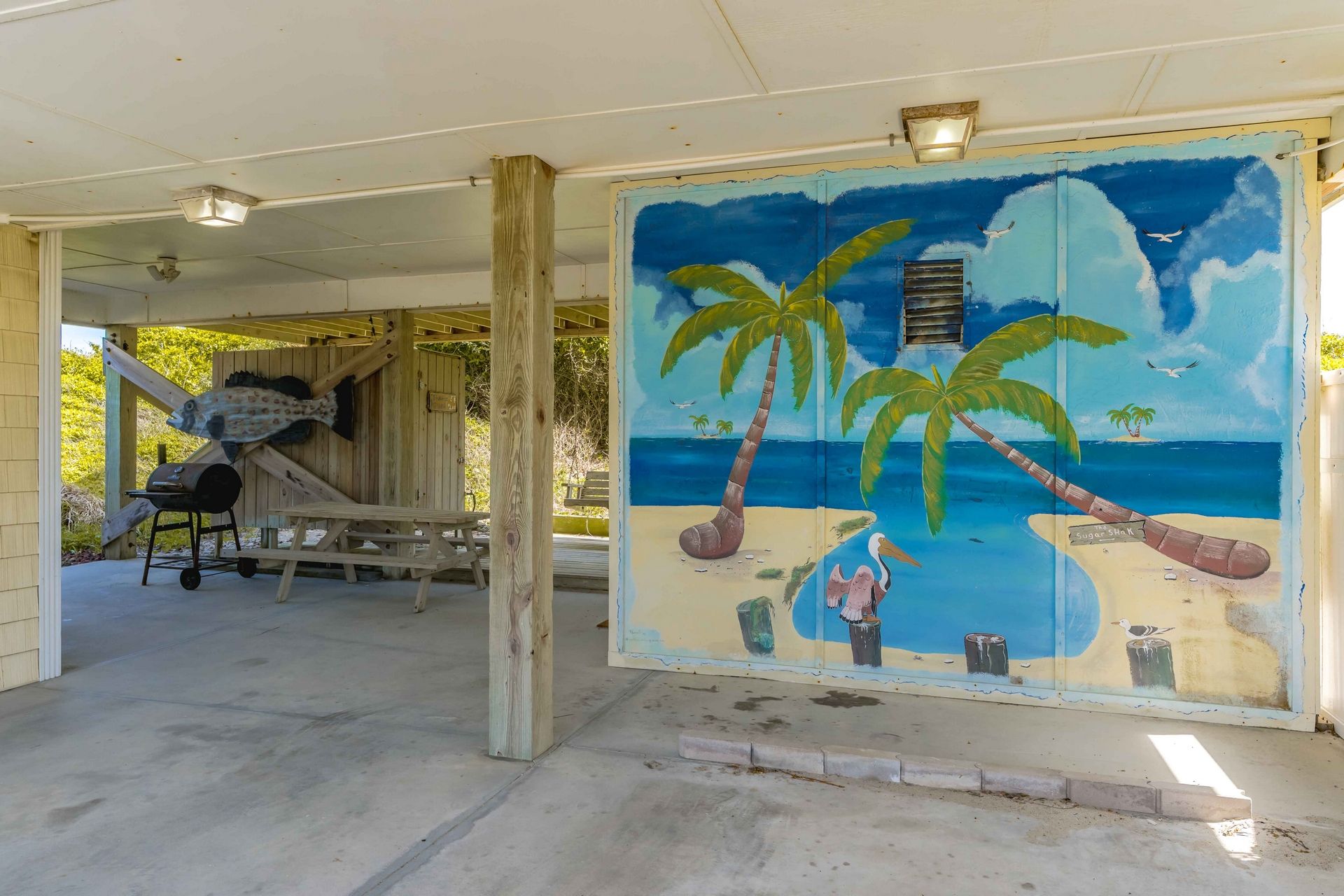 Une fresque murale sur le thème de la plage, avec des palmiers et une scène de plage.