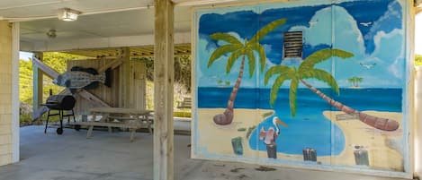 Une fresque murale sur le thème de la plage, avec des palmiers et une scène de plage.