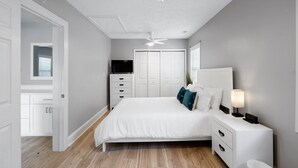 A bedroom with a bed, bedside table, lamp, and a ceiling fan. - 3 Blocks to Beach/Downtown & 2 Parking Spots, 3 BLOCKS FROM THE BEACH & BOULEVARD -Lindy's Landing (Carolina Beach)