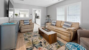 A modern living room with two beige sofas, a wooden coffee table, and a large mirror. - 3 Blocks to Beach/Downtown & 2 Parking Spots, 3 BLOCKS FROM THE BEACH & BOULEVARD -Lindy's Landing (Carolina Beach)