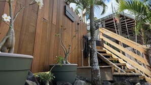 A wooden building with a staircase, potted plants, and a wooden deck. - Villa ATOLA with swimming pool 800m from Le Diamant beach in Martinique. (Le Diamant)