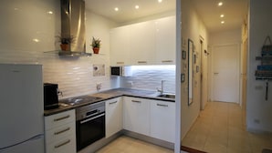 A modern kitchen with white cabinets, stainless steel appliances, and a tiled backsplash. - Charming House by the Canal with Terrace - Roses (Roses)