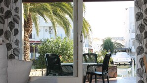 A room with a view of a street, featuring a sofa, two chairs, and a table. - Charming House by the Canal with Terrace - Roses (Roses)