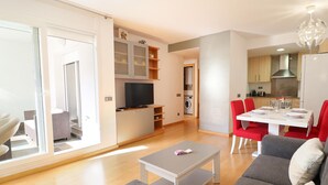 A modern apartment with a living room, dining area, kitchen, and a balcony.