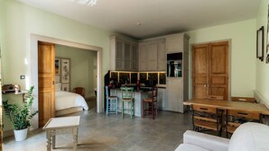 A compact living space with a kitchenette, a dining area, and a bedroom. - Charming air-conditioned apartment, central Pézenas, pets welcome (Pézenas)