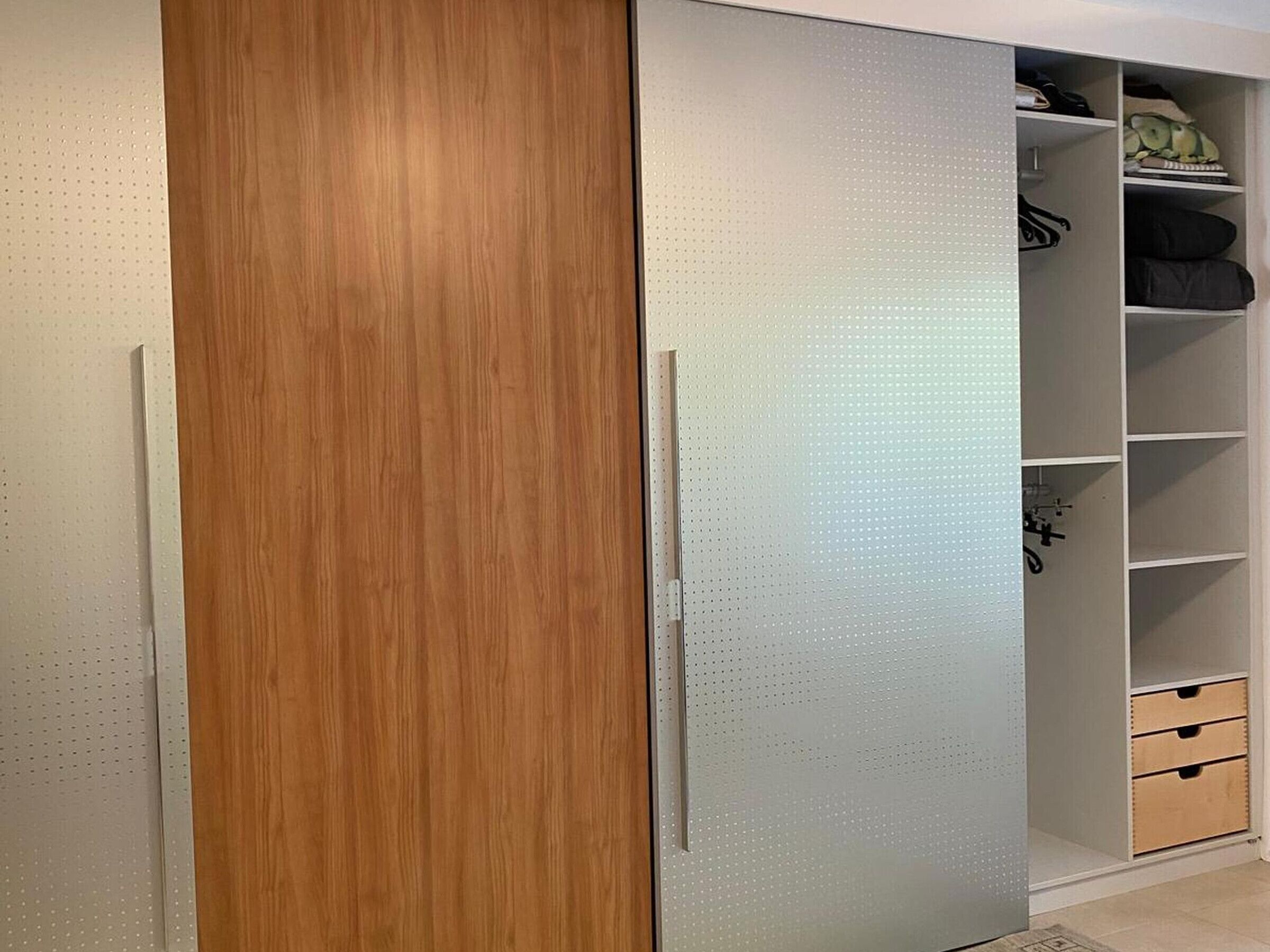 A wardrobe with a wooden door and a mirrored panel.