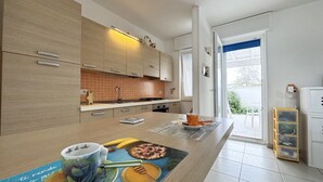 Una cocina moderna con armarios de madera, salpicadero de azulejos y una zona de desayuno en la isla.