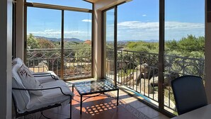 A balcony with a glass table and chairs, offering a view of a mountainous landscape. - Spacious house with air conditioning and pets allowed in Pau (Pau)