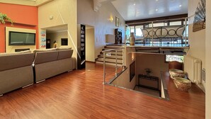 A spacious living area with a sofa, a television, and a bookshelf. - Spacious house with air conditioning and pets allowed in Pau (Pau)