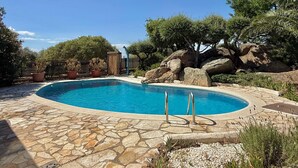 A swimming pool with stone tiles, surrounded by rocks and trees. - Spacious house with air conditioning and pets allowed in Pau (Pau)