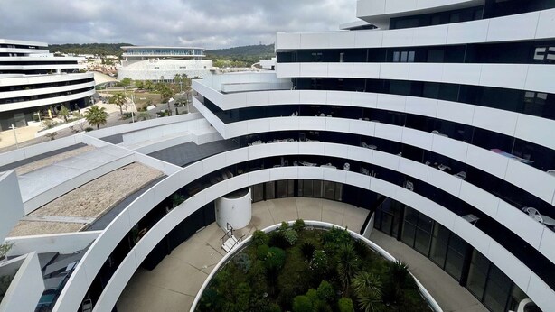 A modern multi-story building with curved balconies and a central courtyard with greenery. - Beautiful new apartment for 4 with terrace, Cap d'Agde (Cap d'Agde)