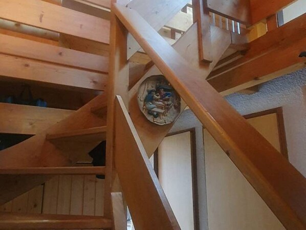 A wooden staircase with a circular object hanging from the ceiling.