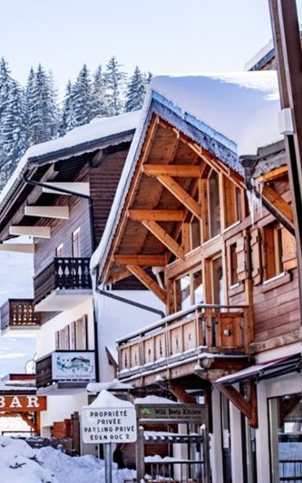 A wooden building with balconies and a sign indicating private parking.