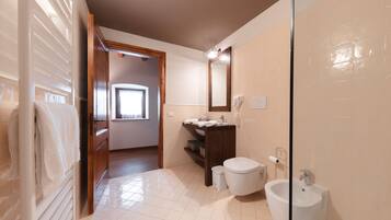 A bathroom with a toilet, bidet, and a mirror.