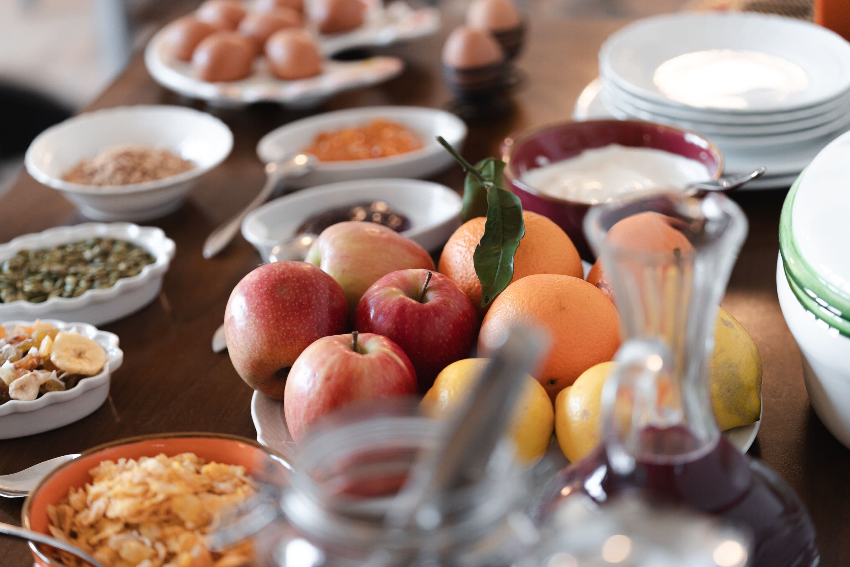 Una mesa con diversos alimentos, entre ellos frutas, verduras y salsas.