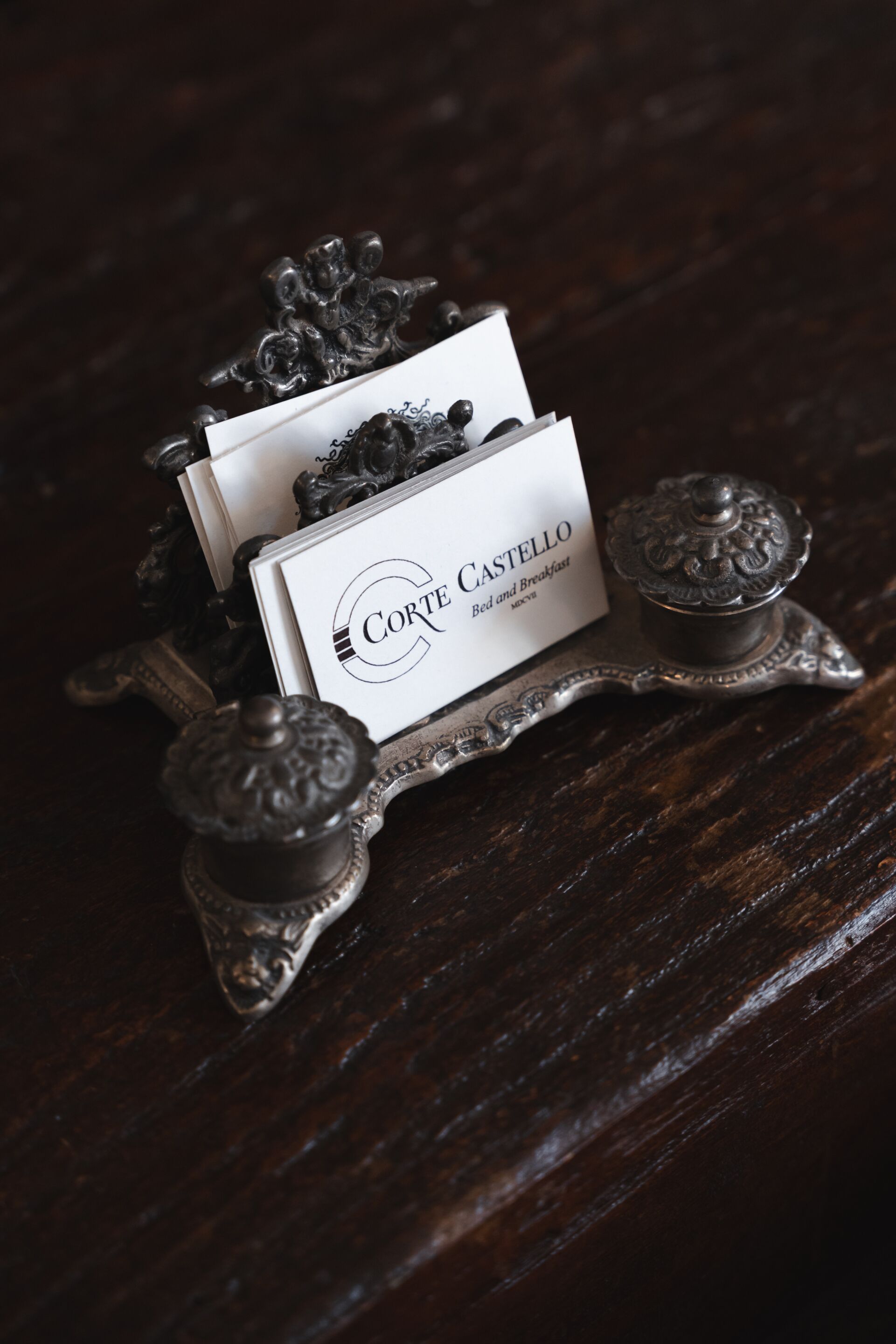 Ein Tablett mit einem Namensschildständer und einer Karte mit der Aufschrift 'Corte Castello Bed and Breakfast'.