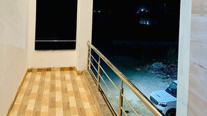 Un balcon doté d’un plancher en bois et d’une rambarde en métal.