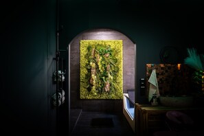 A hallway with a green wall mural, a dark floor, and a small table with a plant. - juloft-Private wellness suite for couples with whirlpool, sauna & style (Leverkusen)