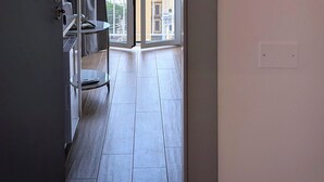 A room with a sliding glass door leading to a balcony with a city view. There is a sign on the wall indicating room number 606. - Incoming Roof Bovio (Naples)