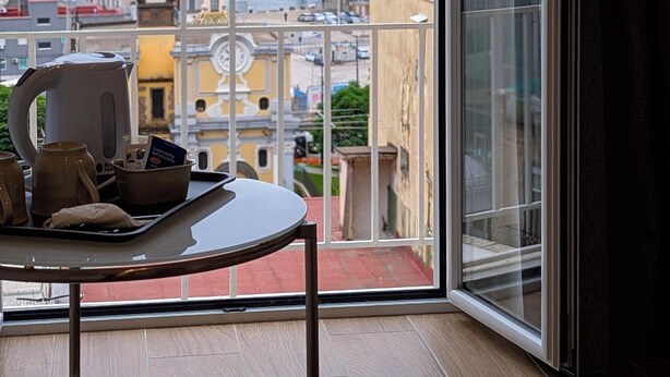 A balcony with a table, a kettle, and a tray of items. - Incoming Roof Bovio (Naples)