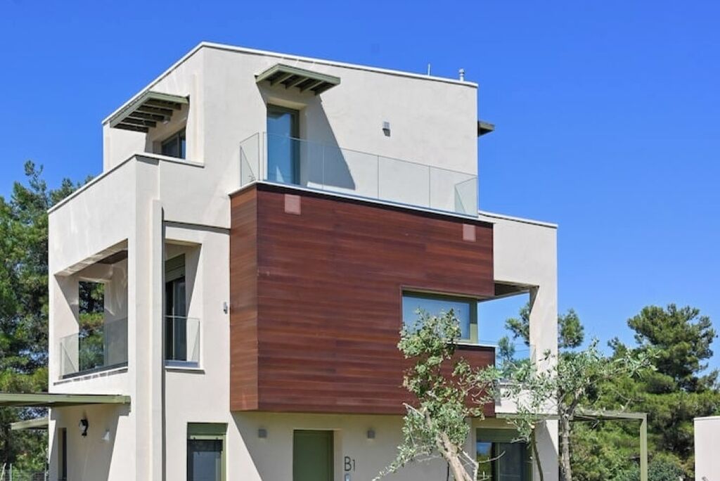A modern two-story building with a flat roof, large windows, and a mix of white and brown exterior walls.