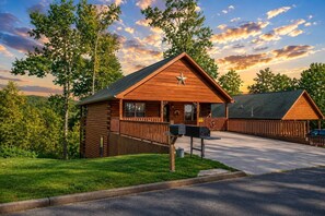 A log cabin-style building with a porch, a mailbox, and a clear sky. - Luxury Theatre Cabin: Lights, Camera, Relax (Sevierville)