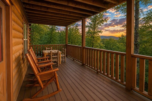 A wooden deck with a table and chairs, overlooking a forested landscape. - Luxury Theatre Cabin: Lights, Camera, Relax (Sevierville)