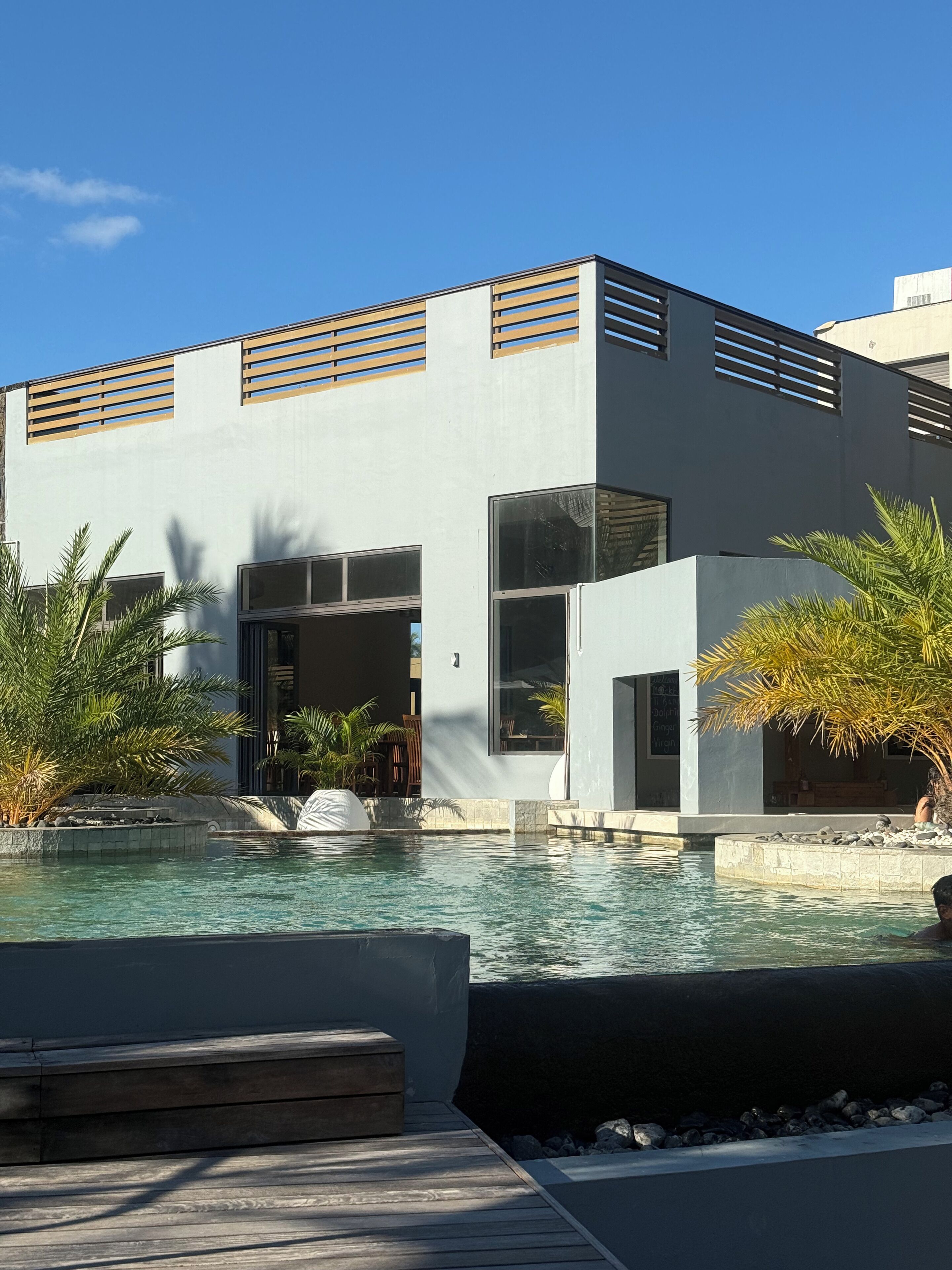 Un bâtiment moderne doté d’une piscine, de grandes fenêtres et d’un design minimaliste.