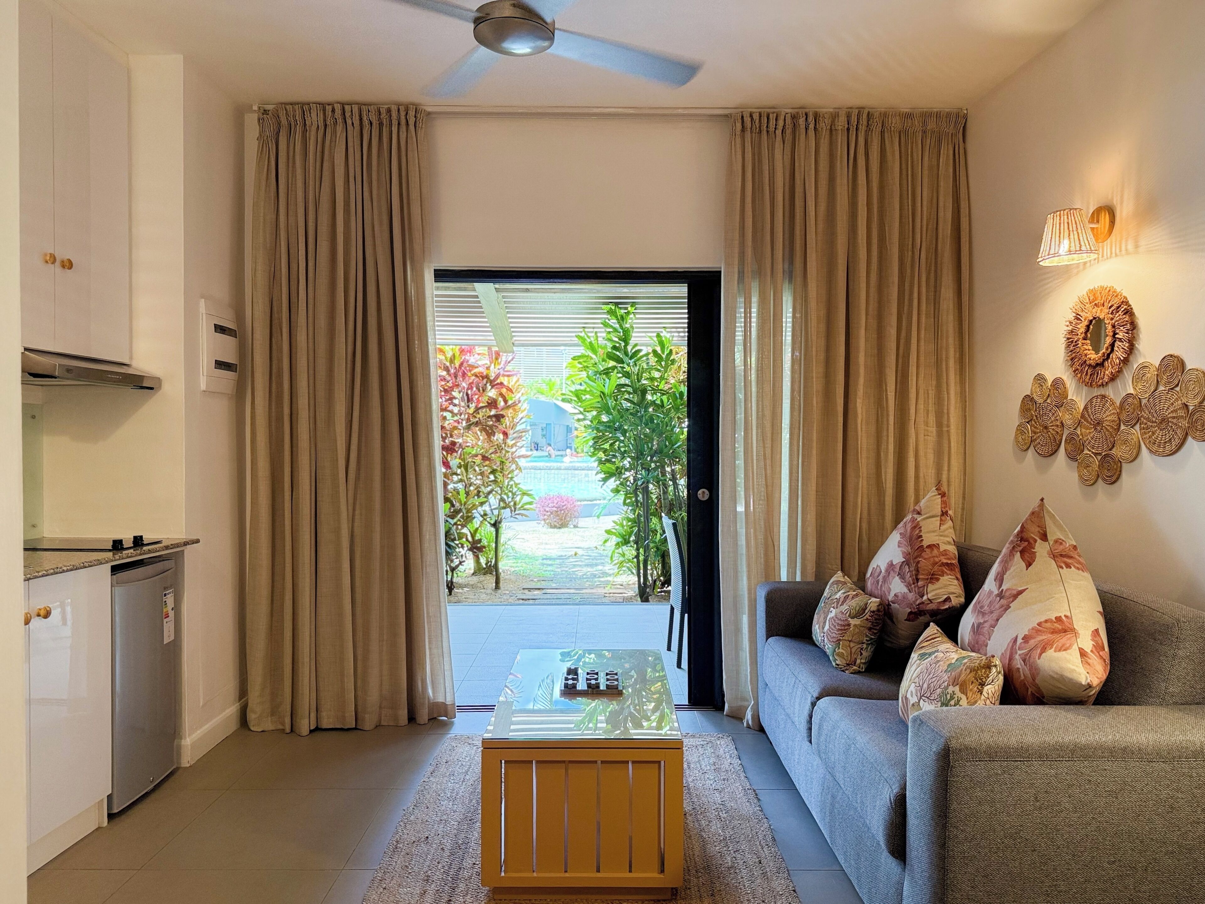 A living room with a sofa, coffee table, and curtains.