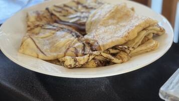 A plate of crepes on a table with a black tablecloth.