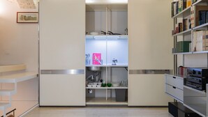 Eine moderne Küche mit weißen Schränken, einer integrierten Spüle und einer Arbeitsplatte mit Kaffeemaschine.