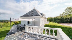 A house with a stone patio, outdoor furniture, and a white railing. - Spacious family home in Brizay, Near Chinon and Azay-le-Rideau (Up to 15 Guests) (Brizay)