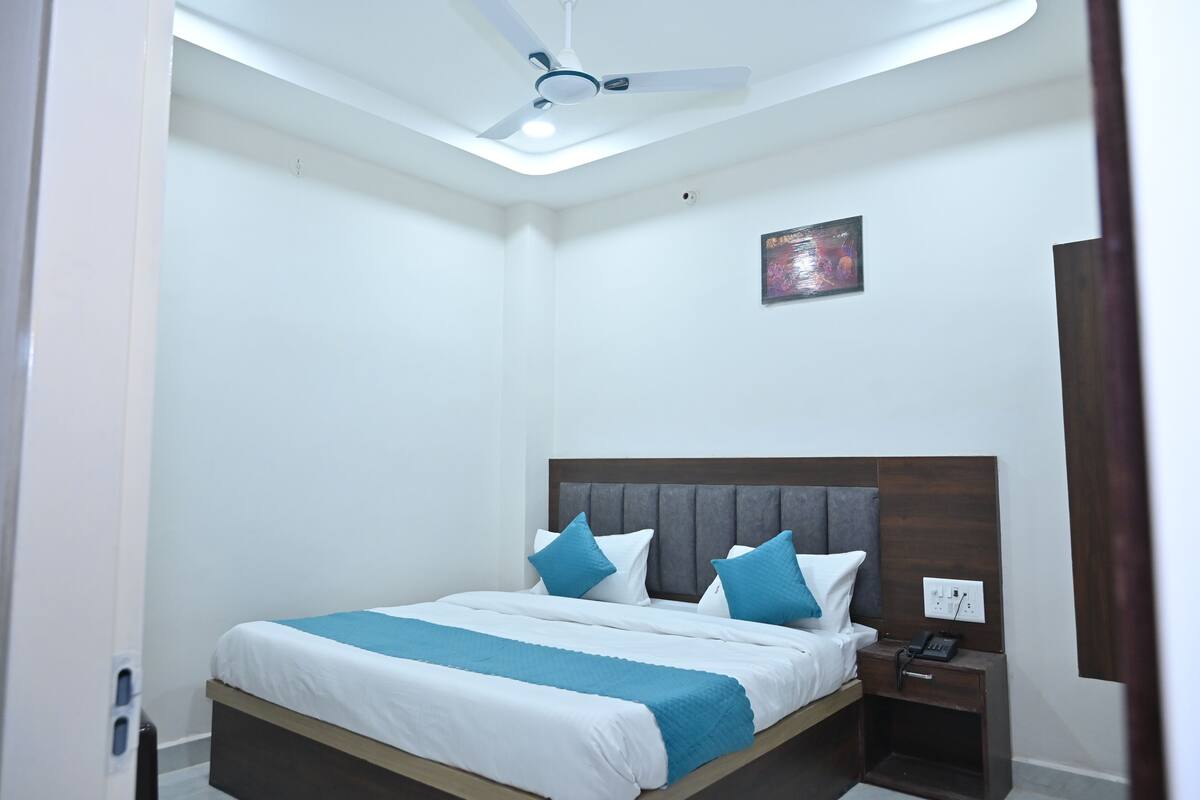 A neatly arranged bedroom with a bed, bedside table, and a ceiling fan.