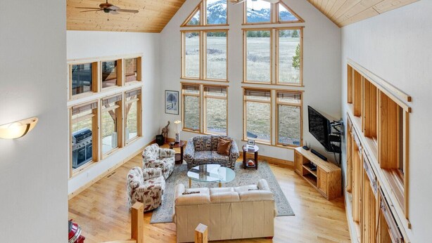 Un salón amplio con ventanas grandes, chimenea y una zona de estar acogedora.