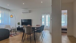 A modern living room with a dining area, a flat-screen TV, and a large window with curtains. - #HU | Le Coeur Lorraine 🥐  | City center/Station T3 (Grenoble)