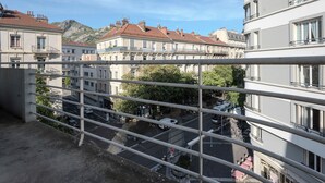 A balcony with a metal railing overlooking a street with parked cars and buildings. - #HU | Le Coeur Lorraine 🥐  | City center/Station T3 (Grenoble)