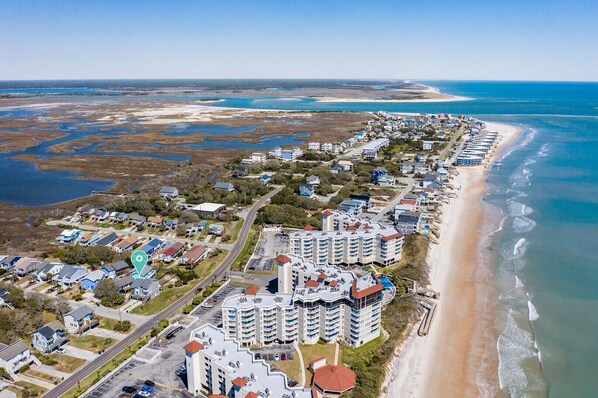An aerial view of a coastal residential area with beachfront properties, including multi-story buildings and single-family homes, along a sandy beach. - Stunning Second Row Duplex, Easy Beach Access, Pet-friendly (North Topsail Beach)