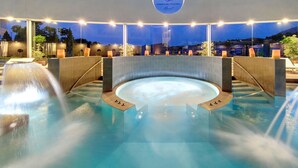 An indoor swimming pool with a central hot tub, surrounded by seating areas and a view of the night sky. - La Vida Feliz Andalucia – Andalusian Garden, Sea Views | Higueron West, Fuengirola (Fuengirola)